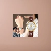 A men's watch with a golden case, white dial and brown leather strap details Picture